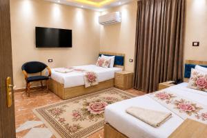 a hotel room with two beds and a flat screen tv at Red Pyramids Hotel in Cairo