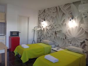 two beds in a room with a wall mural at Lillo Home in Isernia
