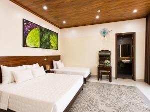 a hotel room with two beds and a bathroom at Daisy's Villa TamCoc in Ninh Binh +44 photos