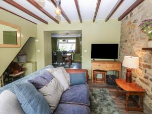 a living room with a blue couch and a tv at Banklands in Barnard Castle