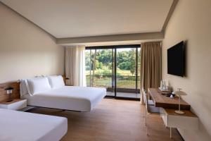 a hotel room with a bed and a desk and a window at Best Western Plus Carolus Park Hotel in Sutri