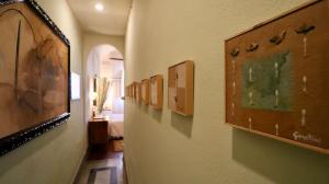a hallway with paintings on the walls of a room at Residenza Palazzo Visdomini in Pietrasanta