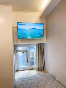 a flat screen tv on a wall in a room with a window at Seoul Grand Hostel Edae in Seoul