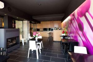 a dining room with a fireplace and a table and chairs at Grupo Izarbe, HOTEL ELLAURI in Zeanuri