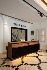 una hall con un tavolo con un cartello sul muro di The Sultan a Singapore