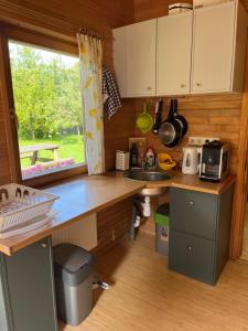 a kitchen with a counter and a sink and a window at Melluzi chalet in Jūrmala