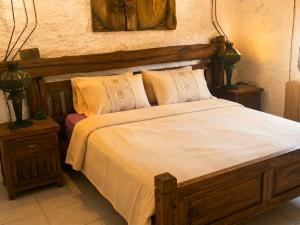 a bedroom with a wooden bed with white sheets and pillows at Cal Catiu in Caserras