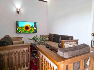 a living room with a couch and a television on the wall at Dishan Green Retreat in Ambalangoda