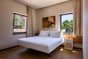 a bedroom with a large white bed and two windows at Best Western Plus Carolus Park Hotel in Sutri +42 photos