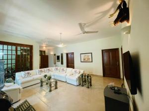 a living room with a white couch and tables at Signature 3 Bed Villa Clifton Boat Basin in Karachi