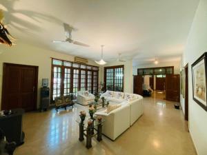 a large living room with a white couch and tables at Signature 3 Bed Villa Clifton Boat Basin in Karachi