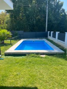 a large blue swimming pool in a yard at GebriDay Apartman in Siófok