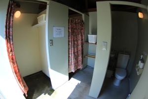 a small bathroom with a toilet and a window at PavilionSurf&Lodge in Shishikui