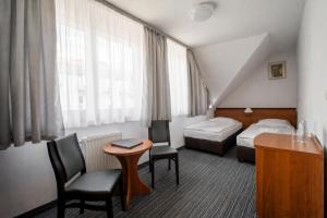 a hotel room with a bed and a desk and a table at Hotel Tanzanit in Jesionka +82 photos