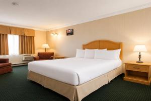 ein großes weißes Bett in einem Hotelzimmer in der Unterkunft Travelodge by Wyndam Chetwynd in Chetwynd