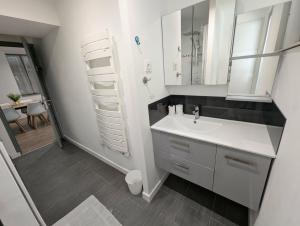 a white bathroom with a sink and a mirror at Maison dans quartier calme proche centre-ville in Château-Gontier
