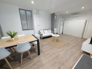 a living room with a dining table and a couch at Maison dans quartier calme proche centre-ville in Château-Gontier