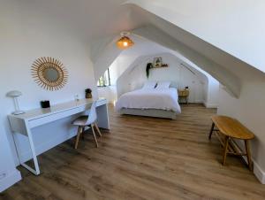a bedroom with a white bed and a desk and a bed istg at Maison dans quartier calme proche centre-ville in Château-Gontier