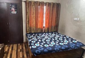 a bedroom with a bed with a blue comforter at Gokul Bhawan in Kedārnāth