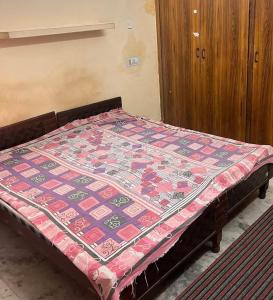 a bed with a quilt on it in a room at Gokul Bhawan in Kedārnāth