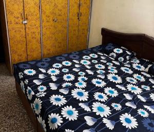 a bedroom with a bed with a blue and white comforter at Gokul Bhawan in Kedārnāth