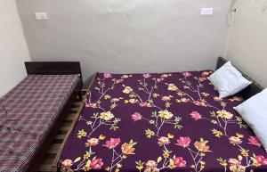 a bedroom with two beds and a purple blanket at Gokul Bhawan in Kedārnāth