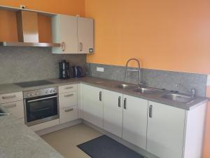 a kitchen with white cabinets and a sink at Herbergskirche Gleidorf in Schmallenberg
