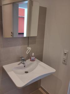 a bathroom with a white sink and a mirror at Herbergskirche Gleidorf in Schmallenberg