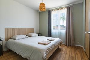 a bedroom with a bed with two towels on it at Le Beauregard - Piscine in Beauregard-Baret +21 photos