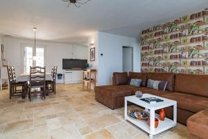a living room with a couch and a table at Le Beauregard - Piscine in Beauregard-Baret