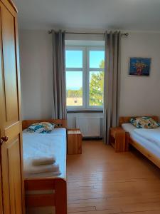 a room with two beds and a window at Młyn Warmiński -Hotelik Hermes in Pieniężno