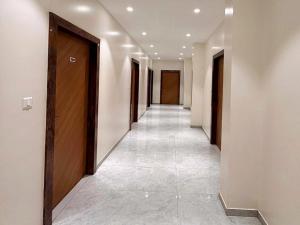 a hallway with a row of doors and a tile floor at Collection O Parsi Point Mahabaleshwar Formerly Jungle Eye in Mahabaleshwar