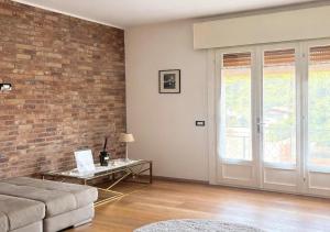 a living room with a couch and a brick wall at Casa Vecellio in Noale