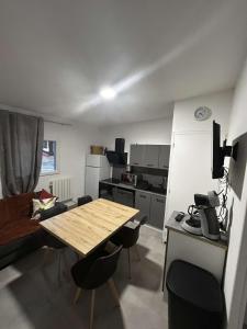 a small kitchen with a wooden table and chairs at appartement 4 pers,tout confort, randonnée, vélo, nature, visite in Laveissière
