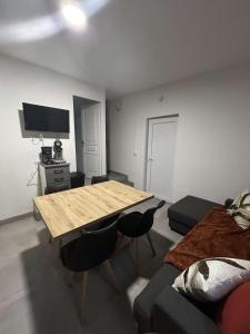 a living room with a wooden table and a bed at appartement 4 pers,tout confort, randonnée, vélo, nature, visite in Laveissière