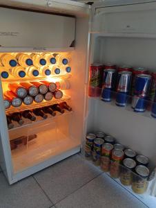 an open refrigerator filled with cans of soda at Pousada Mar de Calma in Montemor-o-Novo