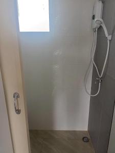 a shower in a bathroom with a phone on the wall at Comfy hotels Suvarnabhumi in Suvarnabhumi Airport