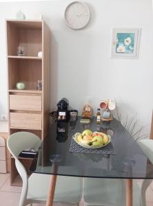 a glass table with a bowl of apples on a plate at Studio Nicki Chania in Chania +2 photos