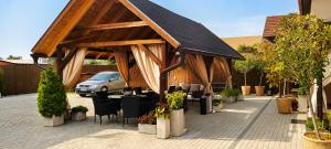 a pavilion with chairs and plants in a parking lot at Harmony apartments in Mórahalom