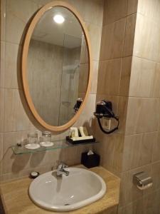 a bathroom with a sink and a mirror at Hotel Chanti Managed by TENTREM Hotel Management Indonesia in Semarang