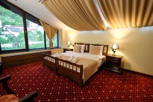 a bedroom with a large bed and a large window at Classic Inn Hotel in Braşov +211 photos