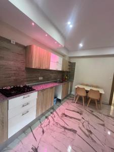 a kitchen with a pink marble floor and a table at luxury apartment in Annaba