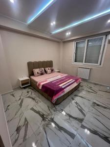 a bedroom with a bed with a marble floor at luxury apartment in Annaba