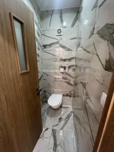 a bathroom with a toilet and a marble wall at luxury apartment in Annaba +6 photos