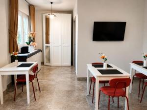 a living room with white tables and red chairs at B&B da Cencia in Monte San Biagio +13 photos