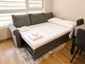 a couch with two pillows on it in a room at Sea Horizon in Burgas