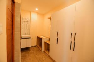 a bathroom with white cabinets and a walk in closet at Adrivana Hospitality By The Stream in Padinjarathara +33 photos