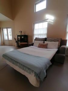 a large bedroom with a large bed with white sheets at Serendipity Guest Cottage in Prince Albert +15 photos
