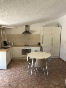 a kitchen with a table and chairs in it at Residence La Beloutiere in Porto-Vecchio