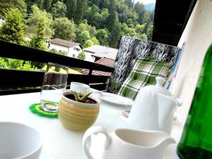 a table with a cup of coffee and a vase at Hofwiese in Hohenschwangau